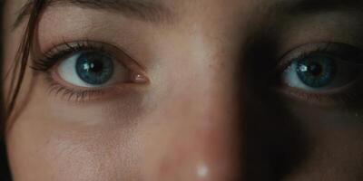 Close up of turquoise colored eyes. Green eyed beautiful girl. Looking directly into the camera. Looking thoughtful. photo