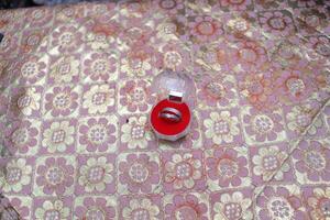 a pair of engagement rings placed in red ring container photo