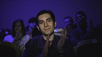 Young man is watching theatrical performance. Media. Man is watching theatrical performance in place. Spectator illuminated by spotlight at theatrical performance photo