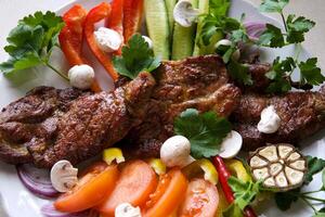 Slices of beef steak with grilled vegetables on cutting board on wooden table, top view Grilled tuna steak in sesame breading with vegetables photo