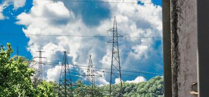 High voltage poles with cloudy skies as a backdrop in the Italian territory of Liguria in the spring of 2024 photo