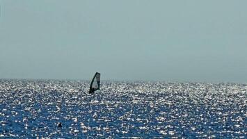 Windsurfing is a sporting activity as well as a sailing specialty which consists of moving on the water on a board thanks mainly to the propulsive action determined by the wind photo