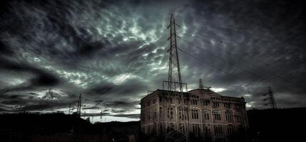 Electricity factory with long-abandoned high voltage cables. dark and noir setting with cloudy sky photo