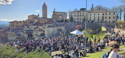 Monforte d'alba, cuneo, Italia. abril, 01, 2024.grupo de festivo y alegre personas celebrar Pascua de Resurrección lunes en Monforte d'alba, en el histórico centro, comiendo y Bebiendo en empresa foto