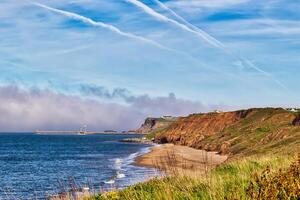 Scenic coastal landscape with beach, cliffs, and pier photo