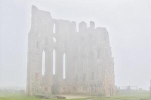 Foggy ancient castle ruin in Tynemouth Priory and Castle photo