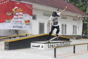Indonesia - Medan, 17 August 2024 an asian man on a skateboard does a crooked grind trick on the box photo