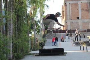 Indonesia - Medan 01 August 2023 an asian man doing skateboard tricks on a ramp photo