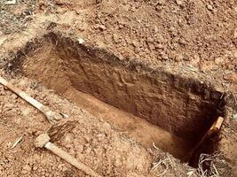 grave with shovel and shovel in the ground photo