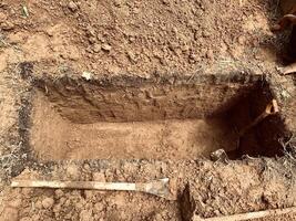 grave with shovel and shovel in the ground photo