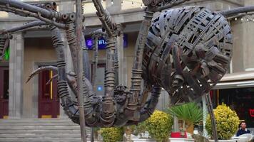 Large rebar spider. ACTION. There is a sculpture of a metal spider on the street. A sculpture of a huge spider was placed in front of the building video