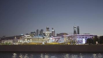 Sailing on boats with view of glowing night city. Action. Boats on city river on background of beautiful night city. Modern glowing city by river at night video