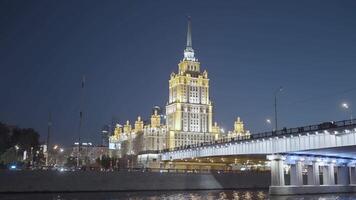 Moscow 2021. Action. Beautiful huge evening buildings near the river in Moscow were shot from afar on a dark evening with bright lights and lanterns that glow . video