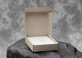 Opened cardboard box on top of black rock with texture use for mockup photo