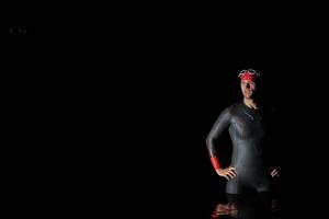 Authentic triathlete swimmer having a break during hard training on night photo
