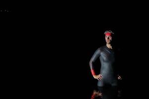 Authentic triathlete swimmer having a break during hard training on night photo