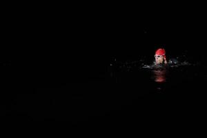Authentic triathlete swimmer having a break during hard training on night photo