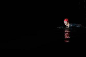 Authentic triathlete swimmer having a break during hard training on night photo