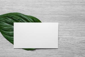 Beautiful Mockup Paper on Wooden Background Combined with Leaves, Creating a Charming and Natural Setting for Creative Designs and Artistic Presentations photo