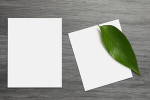 Beautiful Mockup Paper on Wooden Background Combined with Leaves, Creating a Charming and Natural Setting for Creative Designs and Artistic Presentations photo