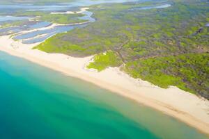 Beautiful Beach View from Above A Stunning Aerial Perspective of White Sands and Blue Waves, Offering Tranquil Serenity and Coastal Splendor in Nature's Idyllic Setting photo