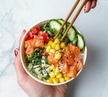 Person Holding Bowl of Food With Chopsticks photo