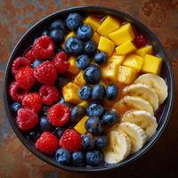 Bowl of Fruit With Bananas, Raspberries, and Blueberries photo