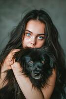 Woman With Blue Eyes Holding Black Dog photo