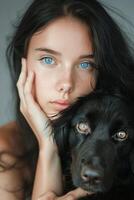 Woman With Blue Eyes Holding Black Dog photo