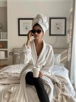 mujer sentado en cama con toalla envuelto alrededor cabeza foto