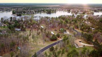 Aerial view of lakeside community with homes and trees. Aerial view of a lakeside community with homes, trees, and roads. video