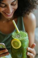 Woman Holding Tablet and Green Smoothie photo