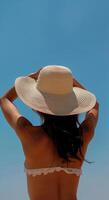 Woman in Bikini and Hat on Beach photo