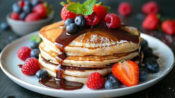 Stack of Pancakes Topped With Berries and Syrup photo