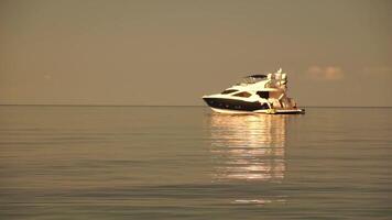 yacht su calma mare. lusso crociera viaggio. lato Visualizza di bianca barca su in profondità blu acqua. vicino su Visualizza di ricco yacht andare in barca mare. estate viaggio su lusso nave. lento movimento video