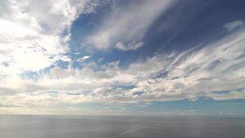 Timelapse multilayered Cirrus and Cumulus clouds moving in bright sunset sky over calm sea. Abstract aerial nature summer ocean sunset, sea and sky view. Vacation, travel. Weather and Climate Change video