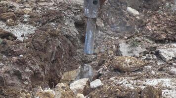 Excavator, trench, stone - Excavator digs stone to create trench on road for new water plastic pipe. construction groundwork. Construction, Infrastructure, development video