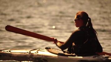 mujer mar kayac. contento sonriente mujer en kayac en océano, remar con de madera remo. calma mar agua y horizonte en antecedentes. activo estilo de vida a mar. verano vacaciones. video