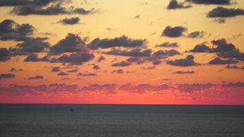 A red burning sunset over sea. Abstract nature summer ocean sea background. Small waves on golden warm water surface with bokeh lights from sun. Weather and climate change video