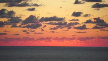 een rood brandend zonsondergang over- zee. abstract natuur zomer oceaan zee achtergrond. klein golven Aan gouden warm water oppervlakte met bokeh lichten van zon. weer en klimaat verandering video