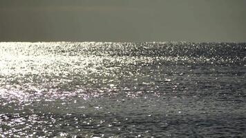 resumen brillante Dom reflexiones en azul superficie de mar ondas. bokeh Dom destello reflejado en agua superficie. el reluciente pequeño mar olas en Dom. mar en soleado día. natural bokeh textura. lento movimiento video