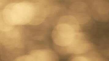 Abstract sea summer ocean sunset nature background. Small waves on golden water surface in motion blur with golden bokeh lights from sun. Holiday, vacation and recreation. Weather and climate change video