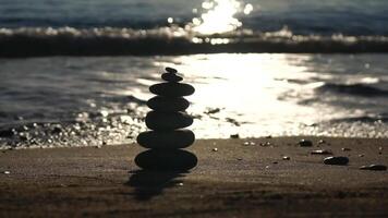 pyramid stenar på de havsstrand med värma solnedgång på de hav hav bakgrund. Lycklig högtider. sandig strand, lugna hav, resa destination. begrepp av Lycklig semester på de hav, meditation, spa, stillhet. video