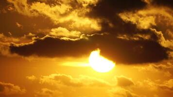 een rood brandend zonsondergang over- zee. abstract natuur zomer oceaan zee achtergrond. klein golven Aan gouden warm water oppervlakte met bokeh lichten van zon. weer en klimaat verandering video