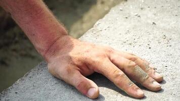 Construction, Worker Hands smooth wet cement in wooden frame at a construction site during daytime to ensure an even surface video