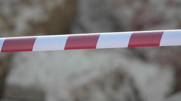 Red and white warning tape swinging in the wind. Protection sign. Don't cross the line. Red White caution tape pole fencing is protects for No entry. Backdrop without people, empty street. video