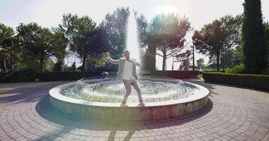 Happy Young Man Dancing in Water Fountain in Summer Time video