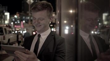 ung affärsman använder sig av läsplatta skärm enhet i de stad video