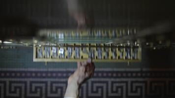 In a dimly lit environment, a hand can be seen reaching through a circuit board video