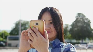 joven asiático mujer utilizando inteligente teléfono tableta en el ciudad calles video